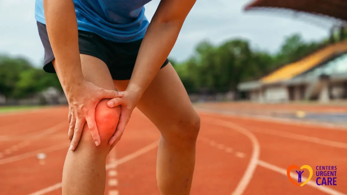 runner-knee-pain-symptoms-athlete-holding-knee-track