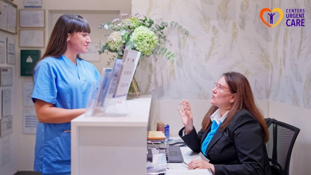 Patient checking in at an urgent care front desk with a staff member