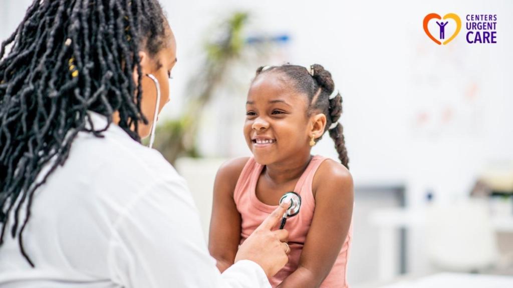 doctor-using-stethoscope-on-smiling-young-girl-at-clinic